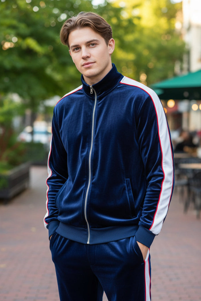 Man wearing a blue velvet tracksuit with white stripes  taken outside