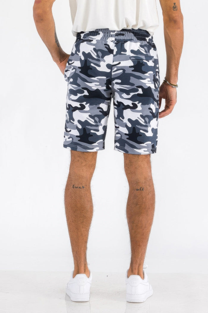 Person wearing camouflage shorts on a white background