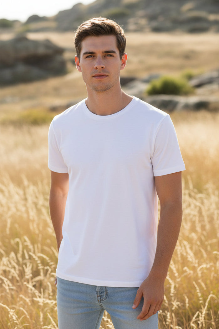 Man wearing a plain white t-shirt and light blue jeans on a white background