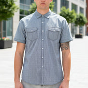 A man wearing a light gray short-sleeve button-up shirt with two chest pockets, 
