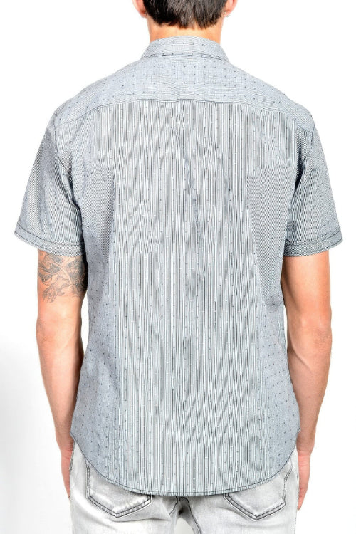 A man viewed from the back wearing a light gray short-sleeve button-down shirt with a subtle dotted pattern, 