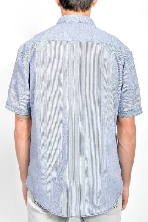 A man viewed from the back wearing a light blue short-sleeve button-down shirt with a subtle textured pattern, 