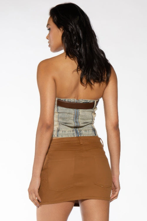 A woman shown from the back wearing a strapless mini dress with a light blue denim corset-style upper section 