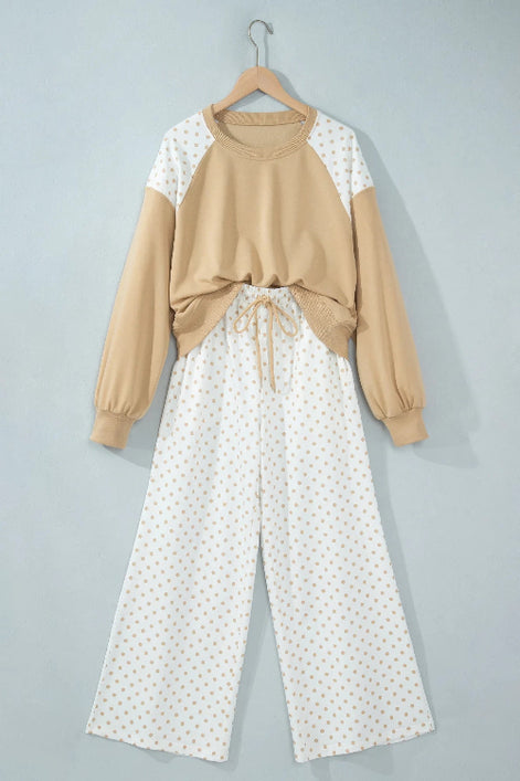 A two-piece women's lounge set hanging on a wooden hanger against a light gray wall. 