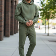 Person wearing a green tracksuit on a white background