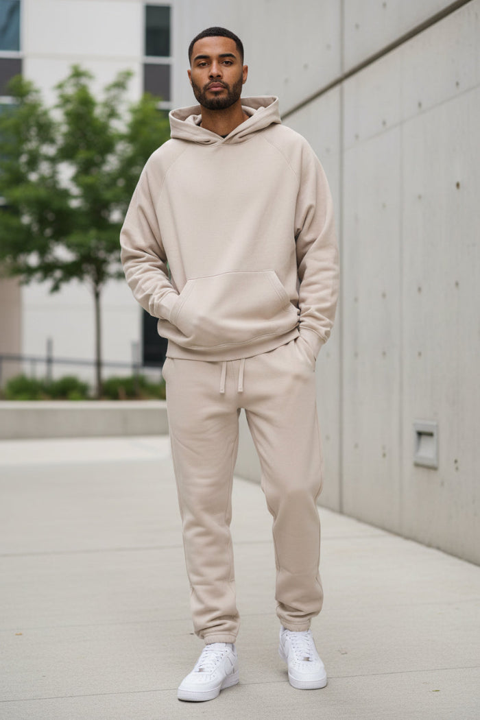 Person wearing a beige tracksuit on a white background