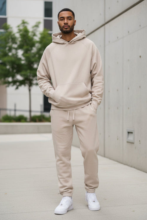 Person wearing a beige tracksuit on a white background