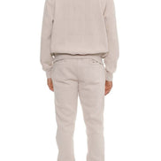 Person wearing a beige hoodie and pants set on a white background