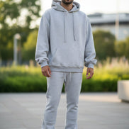 Person wearing a gray hoodie and pants set on outside