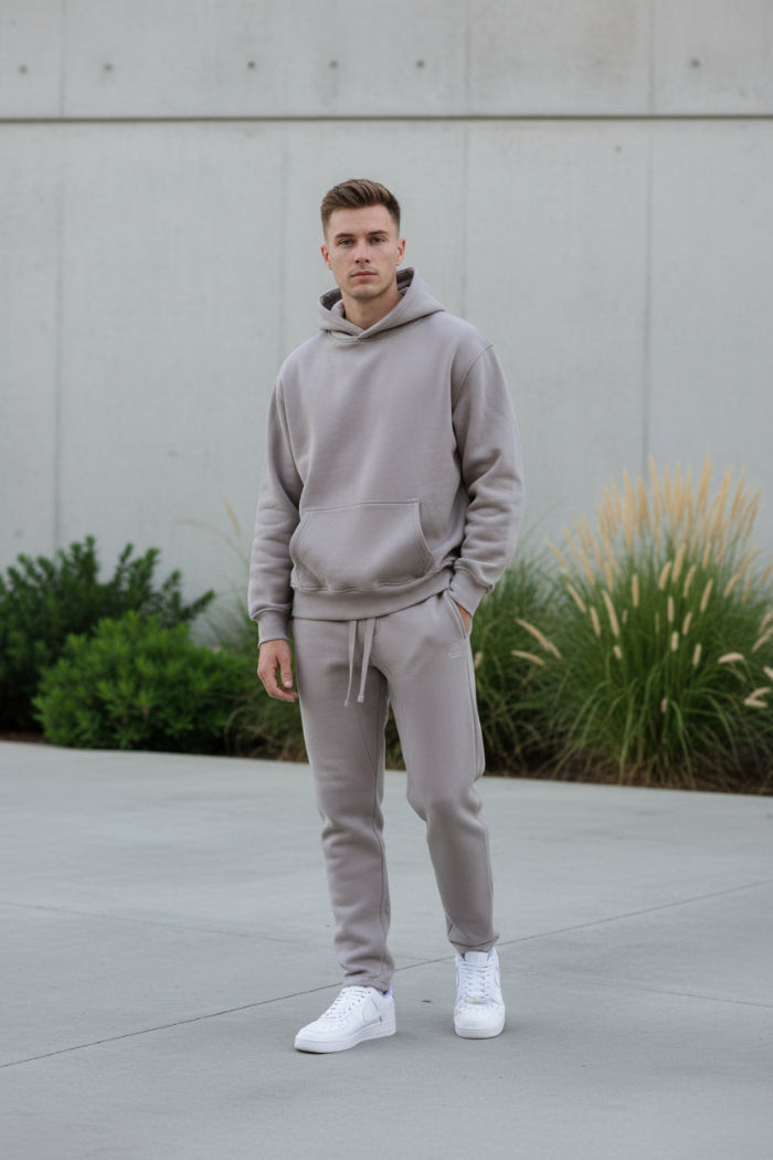 Person wearing a gray tracksuit  outside