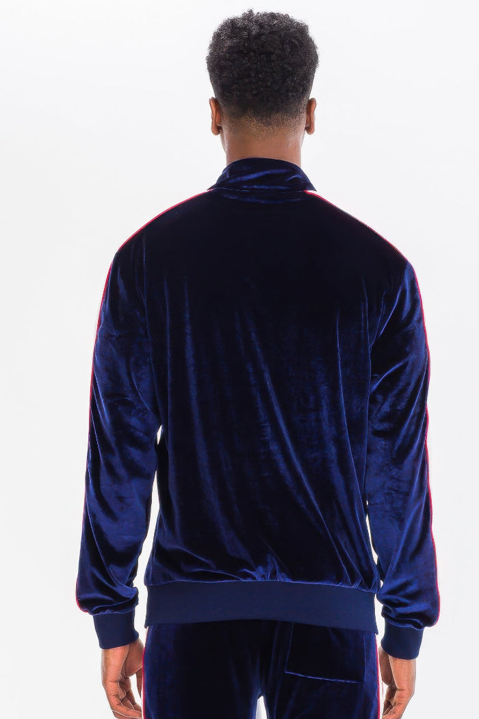 Person wearing a blue velvet tracksuit on a white background