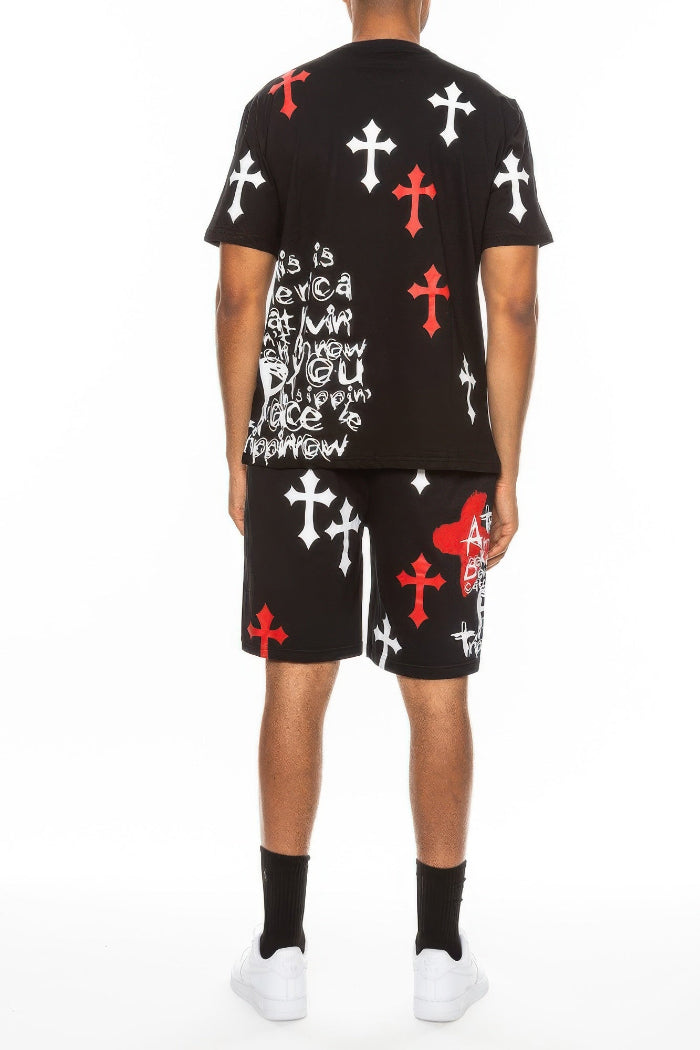 Person wearing a black t-shirt and shorts with red, white, and black designs  taken outside