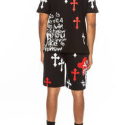 Person wearing a black t-shirt and shorts with red, white, and black designs  taken outside