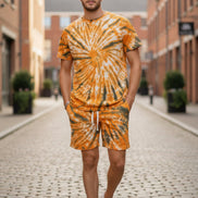Person wearing a tie-dye outfit with orange and black pattern  outside