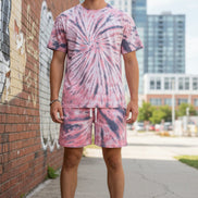 Person wearing a pink and blue tie-dye outfit outside