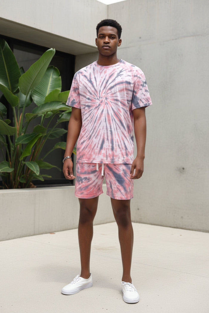 Person wearing a pink tie-dye outfit with shorts and a t-shirt  outside