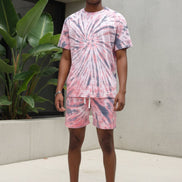 Person wearing a pink tie-dye outfit with shorts and a t-shirt  outside