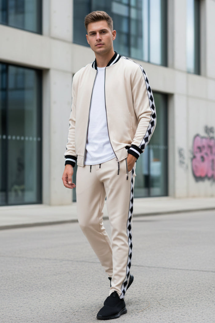 Man wearing a white bomber jacket and pants with black stripes outside