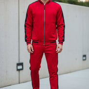 Person wearing a red tracksuit with black accents picture taken outside