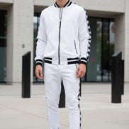 Man wearing a white tracksuit with black stripes taken outside