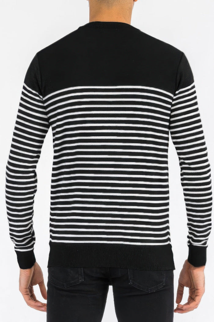 Black and white striped sweater worn by a person on a plain background