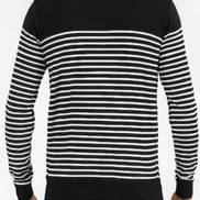 Black and white striped sweater worn by a person on a plain background