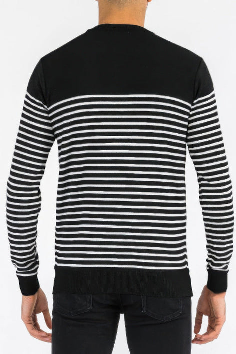 Black and white striped sweater worn by a person on a plain background
