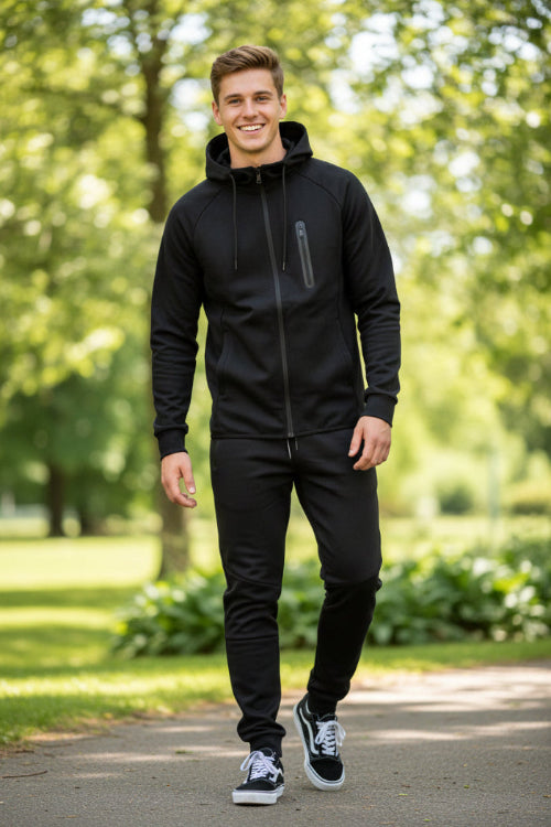 Man wearing a black tracksuit taken outside