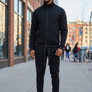 Man wearing a black tracksuit taken outside