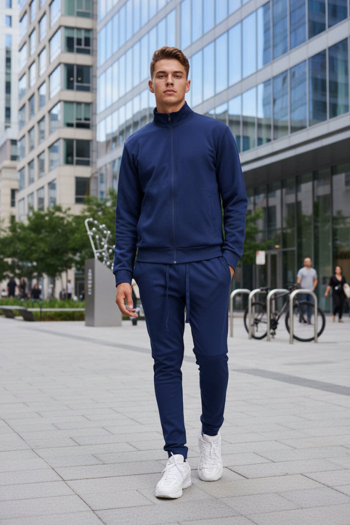 Man wearing a navy tracksuit with white sneakerstaken outside