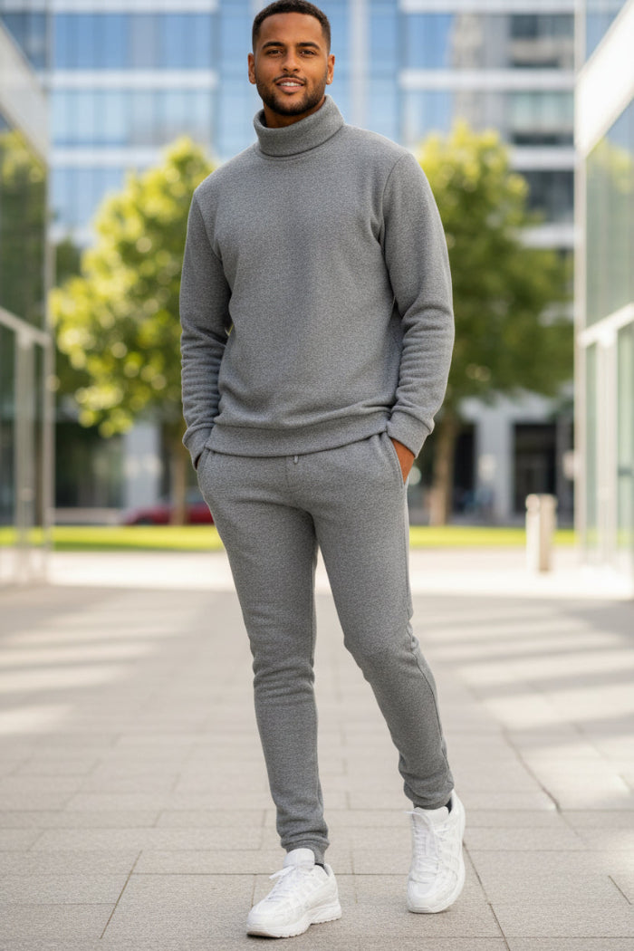 Man wearing a gray tracksuit with white sneakers outside