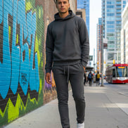 Man wearing a gray tracksuit with white sneakers outside