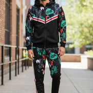 Man wearing a black tracksuit with colorful leaf pattern taken outside