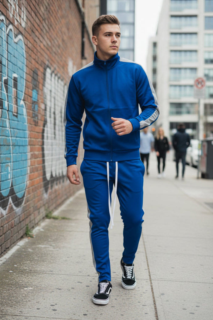 Man wearing a blue tracksuit with white stripes  taken outside