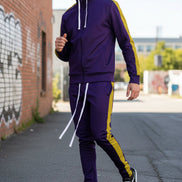 Person wearing a purple tracksuit with yellow stripes taken outside
