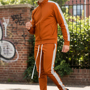 Person wearing an orange tracksuit with white stripes  taken outsie