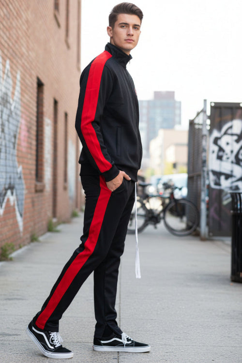 Person wearing a black tracksuit with red stripes  taken outside