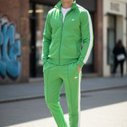 Person wearing a bright green tracksuit with white stripes taken outside