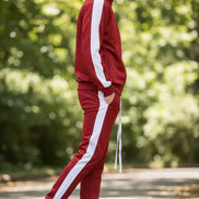 Person wearing a red tracksuit with white stripes  taken outside