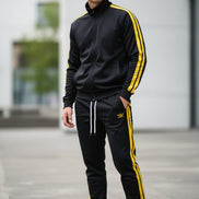 Person wearing a black and yellow tracksuit  taken outside
