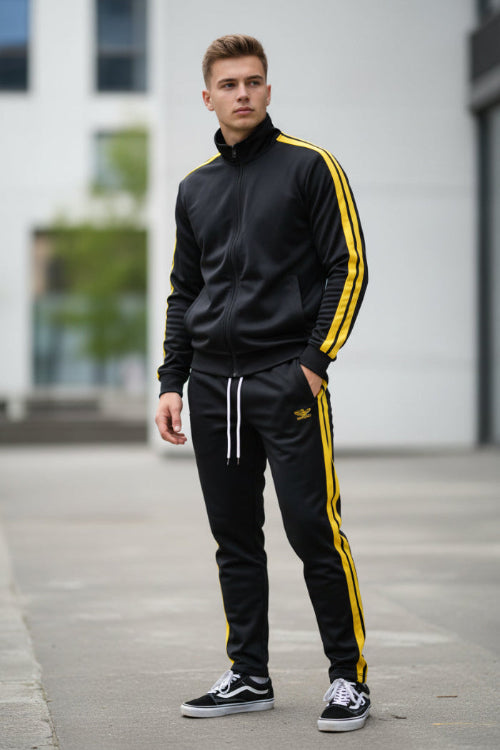 Person wearing a black and yellow tracksuit  taken outside