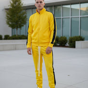 Yellow tracksuit with black stripes worn by a person taken outside