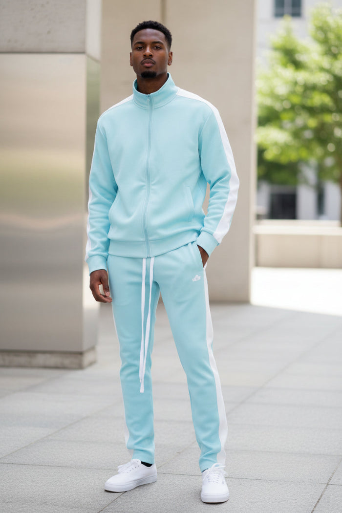 Person wearing a light blue tracksuit with white stripes taken outside