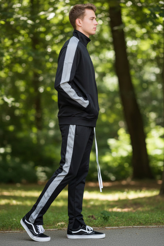 Person wearing a black tracksuit with white stripes taken outside