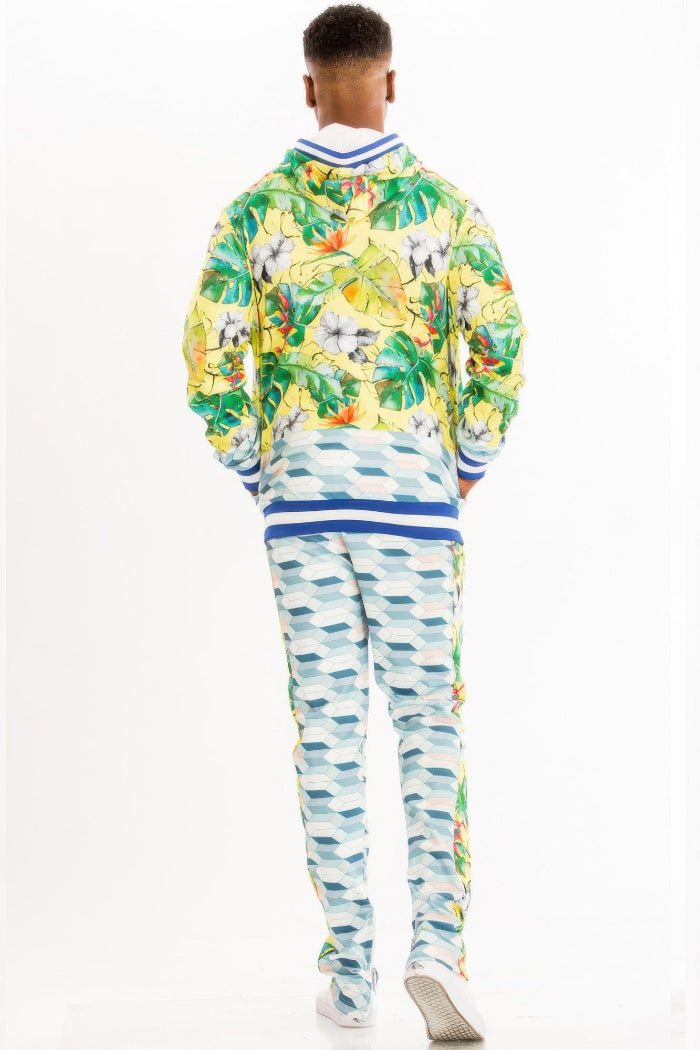 Person wearing a colorful floral jacket and patterned pants on a white background