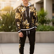 Man wearing a black hoodie with gold floral patterns  taken outside
