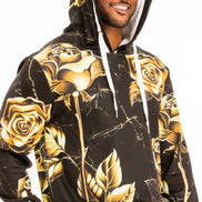 Man wearing a black hoodie with gold rose designs on a white background