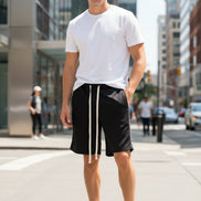 A person wearing black drawstring shorts with white drawstrings, paired with a white top