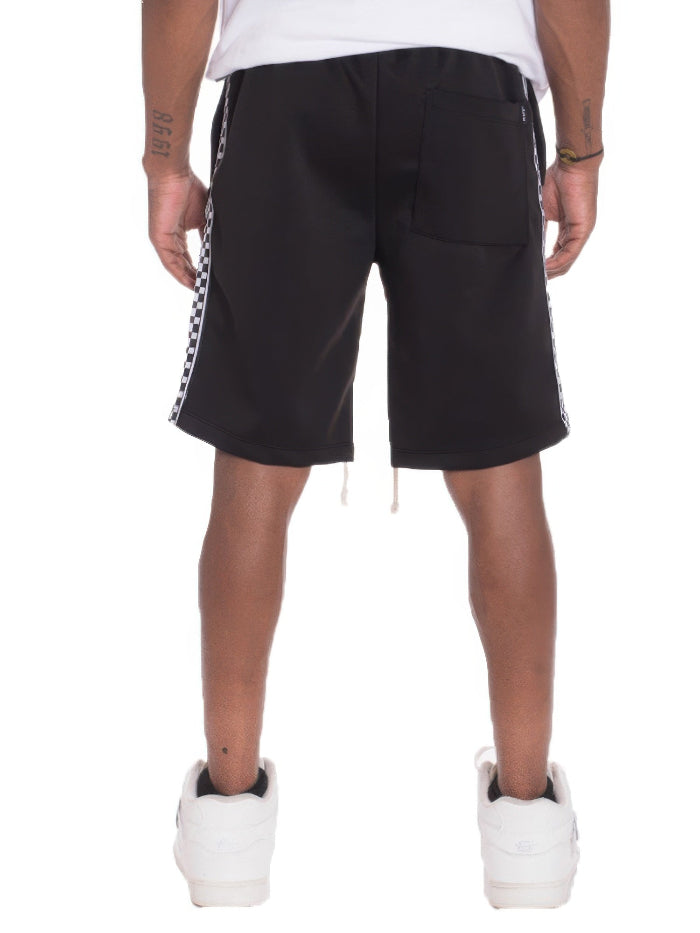 Black shorts with white and red striped side panels worn by a person on a white background