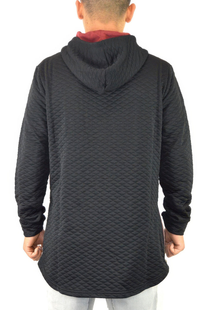Person wearing a black quilted hoodie from behind on a white background